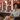 An African American woman seated in a modern salon with warm lighting, soft pink walls, and neatly displayed hair care products, creating a supportive and empowering atmosphere.
