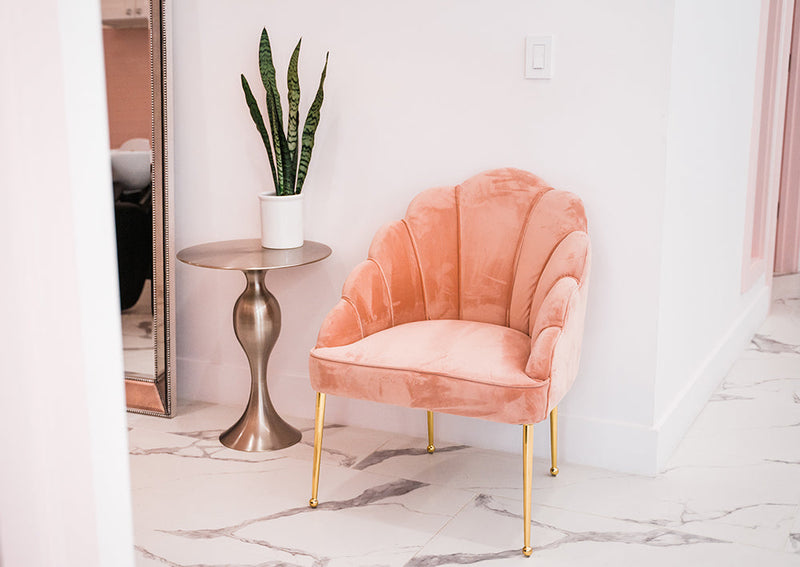 Pink velvet chair and styling vanity in Bond Hair Bar's San Mateo studio interior