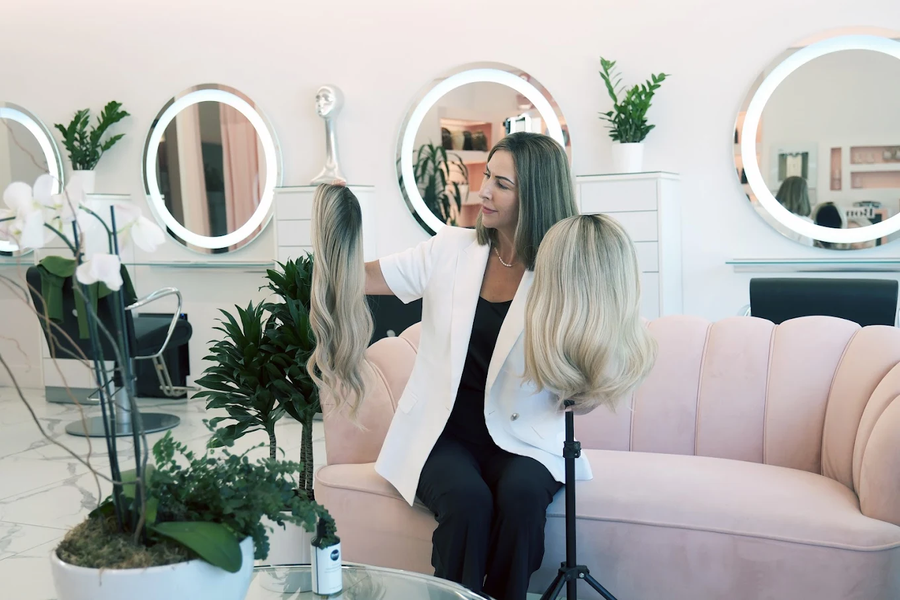 Emily at Bond Hair Bar holding a custom chemotherapy hair system